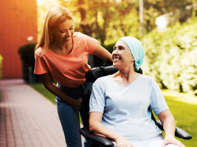 woman on a wheelchair accompanied by her caregiver
